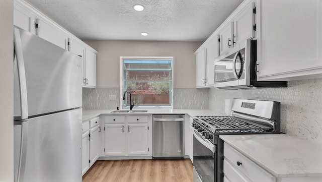 11119 Sidney Ave NE, Albuquerque, NM 87111 - kitchen with white cabinetry, a textured ceiling, appliances with stainless steel finishes, and a sink