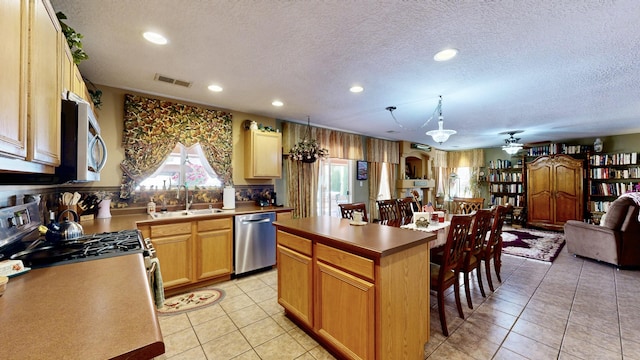 kitchen featuring a sink, stainless steel appliances, a textured ceiling, and visible vents