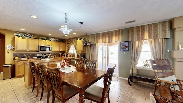 dining space with an inviting chandelier, a textured ceiling, light tile patterned floors, and recessed lighting