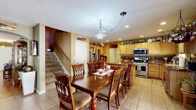 dining room with a textured ceiling, light tile patterned floors, arched walkways, and recessed lighting
