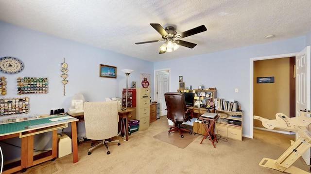 carpeted office space featuring a ceiling fan and a textured ceiling