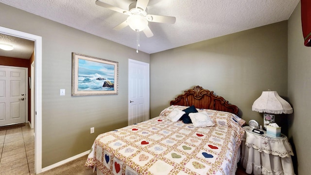 bedroom with a textured ceiling, baseboards, and a ceiling fan