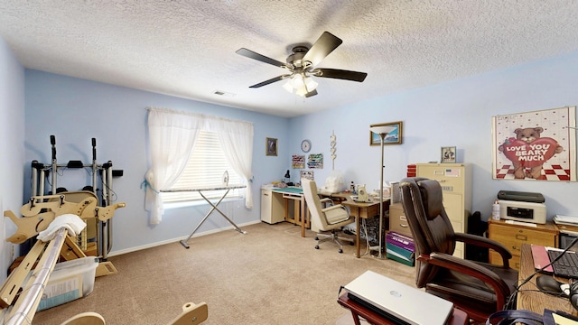 carpeted office featuring a textured ceiling, baseboards, a ceiling fan, and visible vents