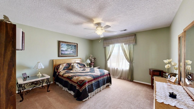 bedroom featuring a textured ceiling, visible vents, ceiling fan, and light carpet