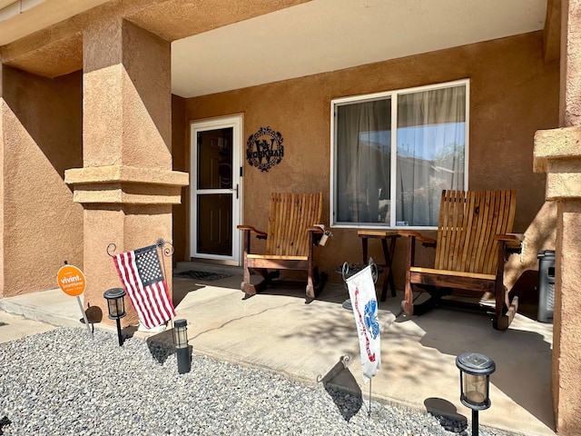 view of exterior entry featuring a patio area and stucco siding