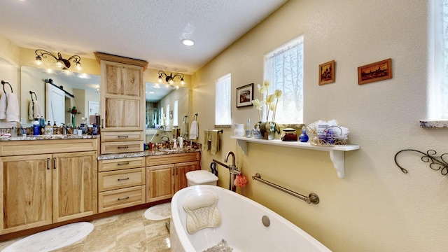 full bathroom with a sink, double vanity, recessed lighting, and a freestanding tub