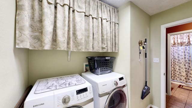 clothes washing area featuring baseboards, laundry area, tile patterned floors, and washer and dryer