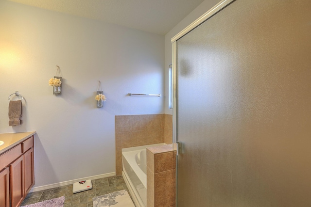 5679 Cold Creek Ave NW, Albuquerque, NM 87114 - bathroom with vanity, baseboards, a bath, and a shower stall