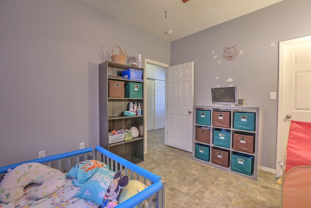 5679 Cold Creek Ave NW, Albuquerque, NM 87114 - bedroom featuring baseboards, stone finish flooring, and a textured ceiling