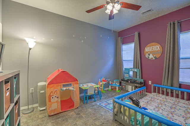 5679 Cold Creek Ave NW, Albuquerque, NM 87114 - bedroom featuring visible vents, baseboards, a textured ceiling, a ceiling fan, and stone finish flooring