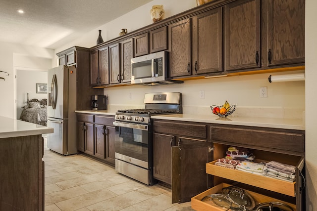 590 Rio Chama Cir SW, Los Lunas, NM 87031 - kitchen with light countertops, stainless steel appliances, light tile patterned flooring, and dark brown cabinets