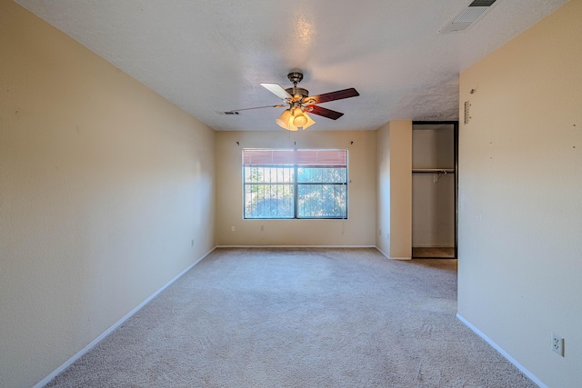 unfurnished bedroom featuring carpet flooring, ceiling fan, baseboards, visible vents, and a closet
