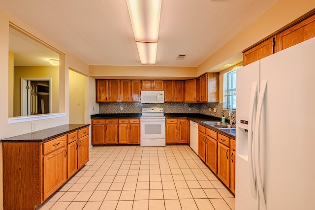 kitchen featuring tasteful backsplash, brown cabinetry, white appliances, and visible vents