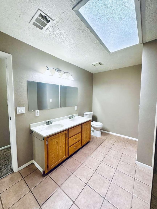 full bath featuring a skylight, visible vents, a sink, and tile patterned flooring