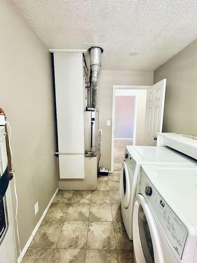 laundry area featuring laundry area, a textured ceiling, baseboards, and separate washer and dryer