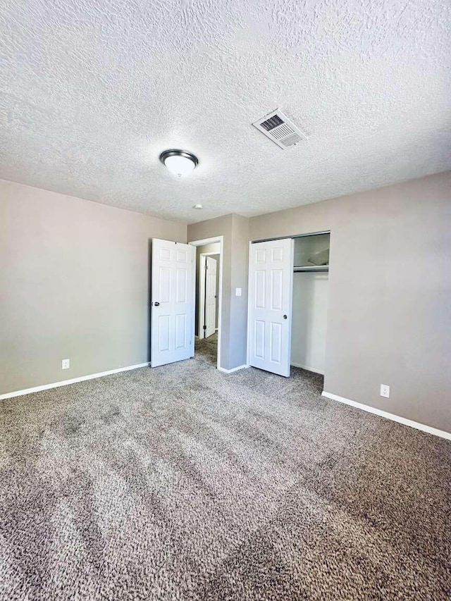 unfurnished bedroom featuring carpet flooring, baseboards, visible vents, and a closet