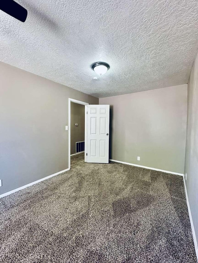 empty room with baseboards, carpet flooring, and a textured ceiling