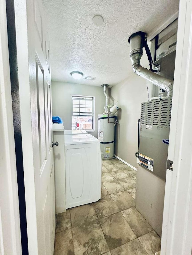 laundry room with secured water heater, a textured ceiling, laundry area, and washer / dryer