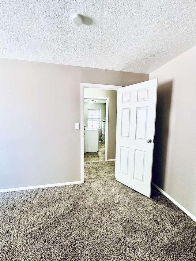 unfurnished bedroom with carpet flooring, a textured ceiling, and baseboards