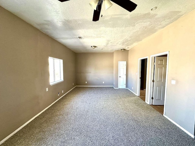 carpeted spare room featuring baseboards, ceiling fan, a textured ceiling, and visible vents