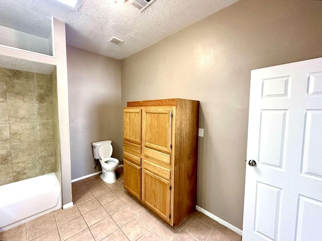 full bathroom featuring a textured ceiling, visible vents, tile patterned floors, baseboards, and toilet