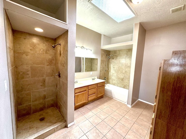 full bath featuring tile patterned flooring, tiled shower / bath, a textured ceiling, and visible vents