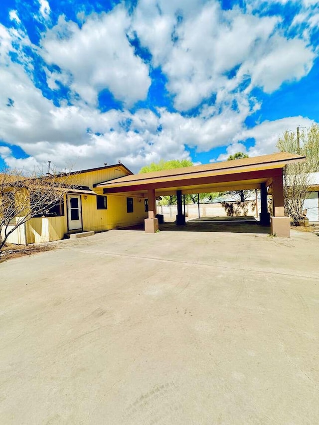 view of car parking with driveway and an attached carport