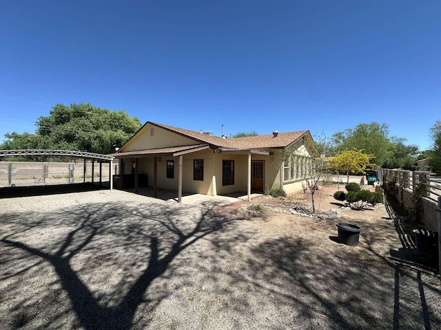 rear view of property featuring fence and a patio area