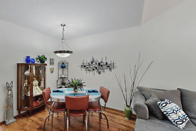 dining space featuring baseboards and wood finished floors