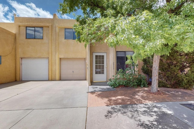view of property featuring an attached garage, driveway, and stucco siding