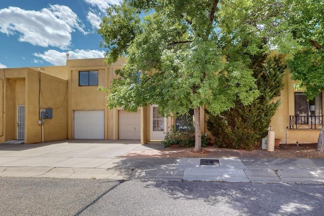 view of front of property featuring concrete driveway, a garage, and stucco siding