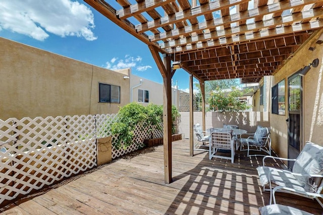 wooden terrace featuring a pergola, fence, and outdoor dining space