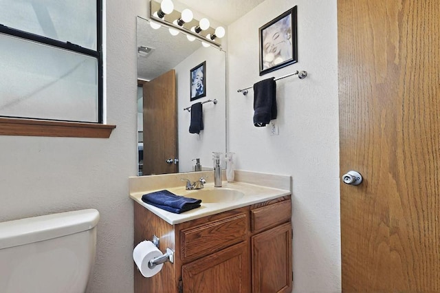 half bathroom featuring vanity and toilet