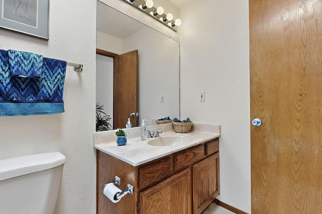 half bathroom with vanity and toilet