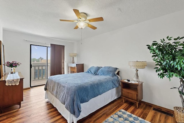 bedroom with a ceiling fan, a textured ceiling, visible vents, wood finished floors, and access to outside