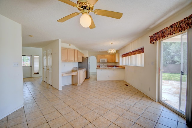 4312 Rancho Centro NW, Albuquerque, NM 87120 - kitchen with freestanding refrigerator, light brown cabinetry, white microwave, light countertops, and light tile patterned floors