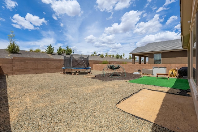 view of yard featuring a playground, a trampoline, a fenced backyard, and central AC