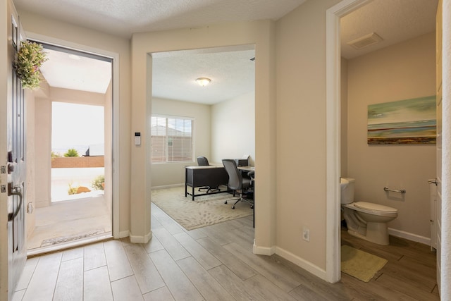 interior space featuring baseboards, visible vents, and light wood-style floors