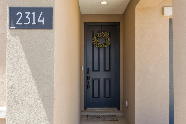 entrance to property featuring stucco siding