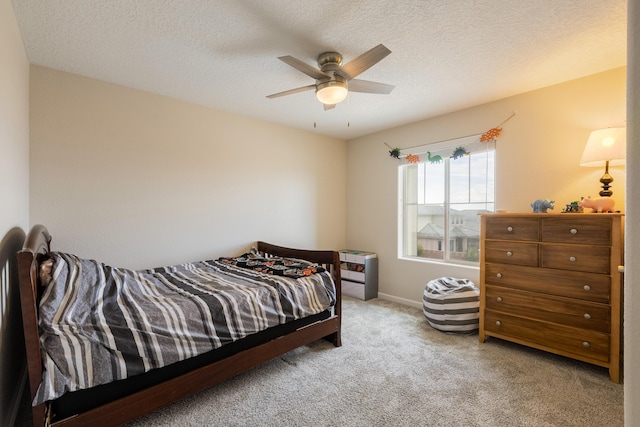 carpeted bedroom featuring baseboards, a ceiling fan, and a textured ceiling