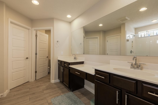 full bathroom featuring recessed lighting, wood finished floors, a shower, and vanity