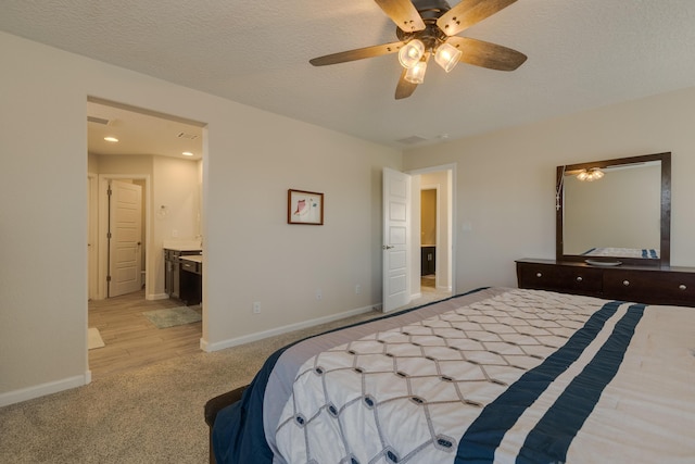 bedroom with baseboards, light carpet, a ceiling fan, and connected bathroom