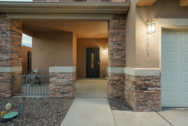 view of exterior entry with stone siding and stucco siding