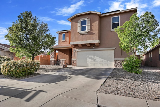 traditional-style home with fence, stone siding, a garage, stucco siding, and concrete driveway