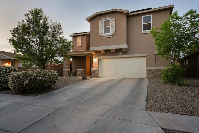 view of front of property with driveway, stone siding, and stucco siding