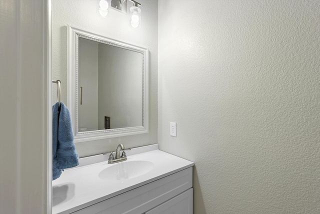 bathroom featuring vanity and a textured wall