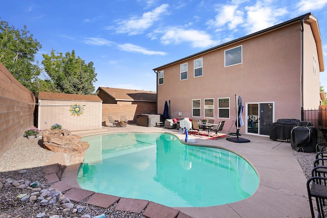 view of swimming pool featuring a storage shed, an outbuilding, a patio area, a fenced in pool, and a fenced backyard