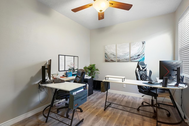 office area with ceiling fan, baseboards, and light wood-style floors
