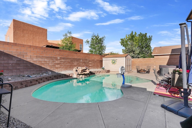view of pool featuring a storage shed, a fenced backyard, a fenced in pool, a patio area, and an outdoor structure