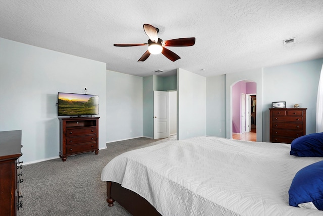 carpeted bedroom with arched walkways, a textured ceiling, visible vents, and baseboards